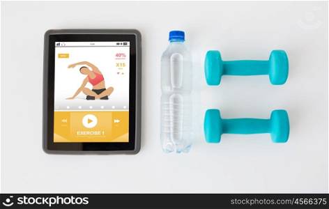 sport, healthy lifestyle, fitness, technology and objects concept - close up of tablet pc computer with dumbbells and water bottle over white background