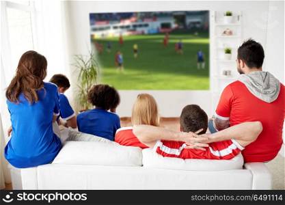 sport, leisure and entertainment concept - friends or football fans watching soccer game on projector screen at home. friends or football fans watching soccer at home. friends or football fans watching soccer at home