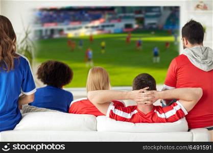 sport, leisure and entertainment concept - friends or football fans watching soccer game on projector screen at home. friends or football fans watching soccer at home. friends or football fans watching soccer at home