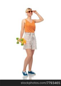 sport, leisure and skateboarding concept - smiling teenage girl in sunglasses and headphones with short modern cruiser skateboard over white background. smiling teenage girl with skateboard over white