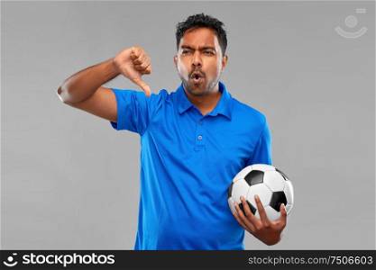 sport, leisure games and failure concept - disappointed indian man or football fan with soccer ball showing thumbs down gesture over grey background. football fan with soccer ball showing thumbs down