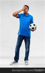 sport, leisure games and failure concept - disappointed indian man or football fan with soccer ball over grey background. upset indian male football fan with soccer ball