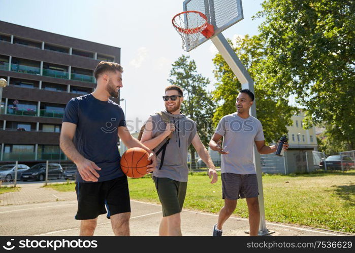 sport, leisure games and male friendship concept - group of men or friends going to play basketball outdoors. group of male friends going to play basketball