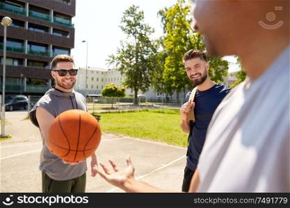 sport, leisure games and male friendship concept - group of men or friends playing street basketball. group of male friends playing street basketball
