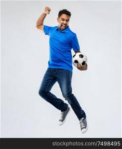 sport, leisure games and people concept - happy indian man or football fan with soccer ball jumping over grey background. man or football fan with soccer ball jumping