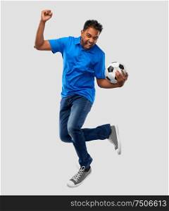 sport, leisure games and people concept - happy indian man or football fan with soccer ball jumping over grey background. man or football fan with soccer ball jumping