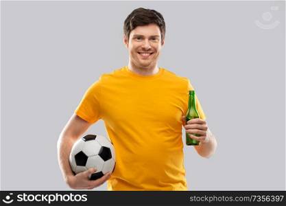 sport, leisure games and people - happy man or football fan in yellow t-shirt with soccer ball and beer bottle over grey background. man or football fan with soccer ball and beer