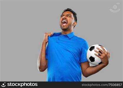 sport, leisure games and success concept - emotional indian man or football fan with soccer ball over grey background. angry indian male football fan with soccer ball