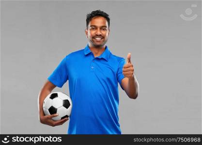 sport, leisure games and success concept - happy indian man or football fan with soccer ball celebrating victory and showing thumbs up over grey background. football fan with soccer ball showing thumbs up