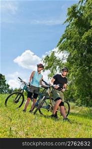 Sport mountain biking happy couple relax in meadows sunny countryside