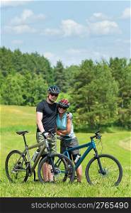 Sport mountain biking happy couple relax in meadows sunny countryside