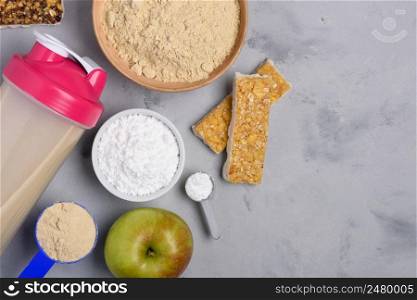Sport nutrition with vegetarian protein powder for cocktail and creatine scoop on concrete background top view flat lay