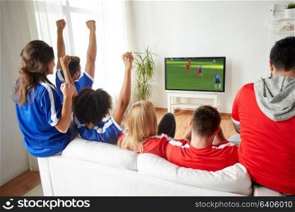 sport, people and entertainment concept - happy friends or football fans watching soccer game on tv and celebrating victory at home. football fans watching soccer game on tv at home