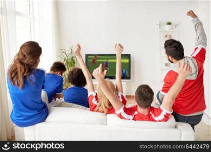 sport, people and entertainment concept - happy friends or football fans watching soccer game on tv and celebrating victory at home. football fans watching soccer game on tv at home