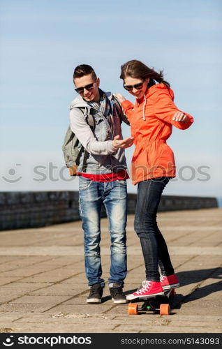 sport, people and leisure concept - happy couple with longboard riding outdoors. happy couple with longboard riding outdoors