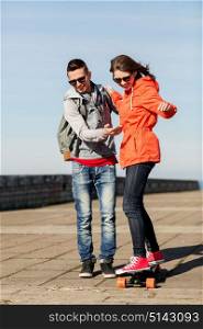 sport, people and leisure concept - happy couple with longboard riding outdoors. happy couple with longboard riding outdoors