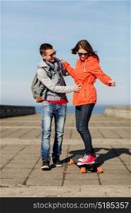 sport, people and leisure concept - happy couple with longboard riding outdoors. happy couple with longboard riding outdoors
