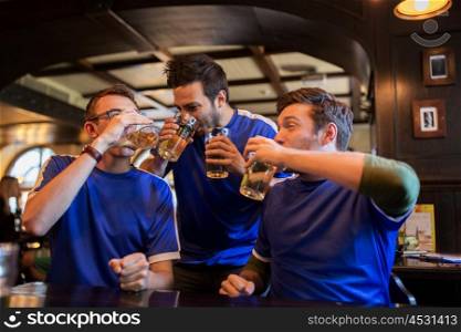 sport, people, leisure, friendship and entertainment concept - happy football fans or male friends drinking beer and celebrating victory at bar or pub