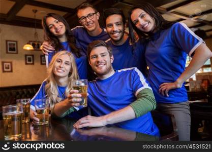 sport, people, leisure, friendship and entertainment concept - happy football fans or friends drinking beer at bar or pub