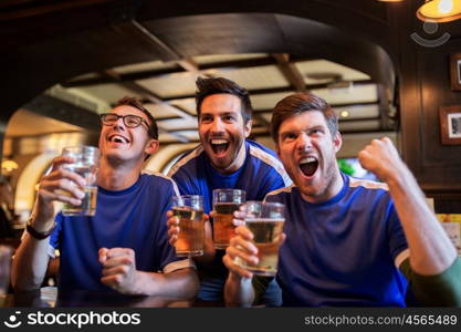 sport, people, leisure, friendship and entertainment concept - happy football fans or male friends drinking beer and celebrating victory at bar or pub