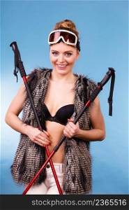 Sport, recreation, people concept. Winter season and lady with sticks. Beautiful girl has fur, brassiere and goggle.. Winter season and lady with sticks.