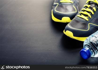 Sport shoes and water on grey background