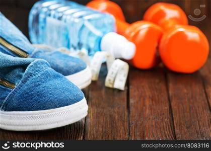 sport shoes and water on the wooden table