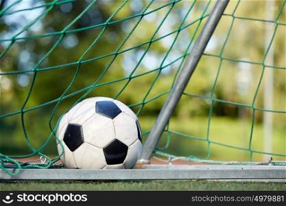 sport, soccer and game - ball at goal net on football field. soccer ball at goal net on football field