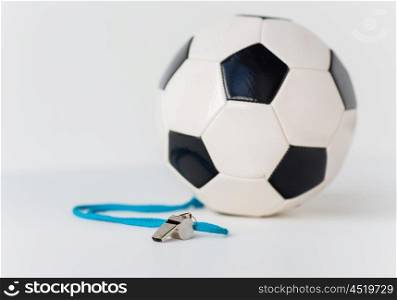 sport, soccer, football, refereeing and sports equipment concept - close up of ball and referee whistle