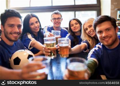sport, soccer, people and leisure concept - happy friends or football fans clinking beer glasses and celebrating victory at bar or pub