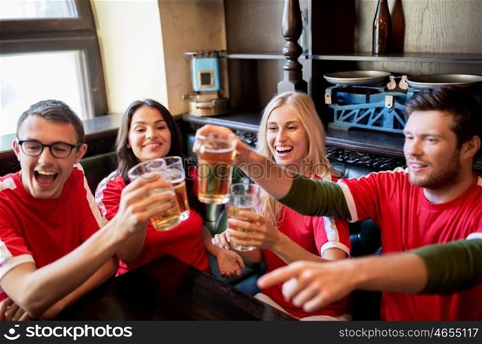 sport, soccer, people and leisure concept - happy friends or football fans clinking beer glasses at bar or pub