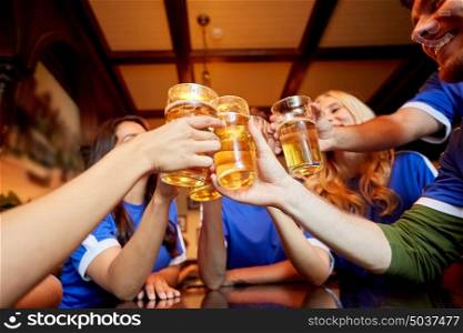 sport, soccer, people and leisure concept - happy friends or football fans clinking beer glasses at bar or pub. football fans clinking beer glasses at sport bar
