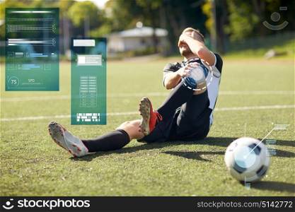 sport, sports injury and people - injured soccer player with ball on football field. injured soccer player with ball on football field