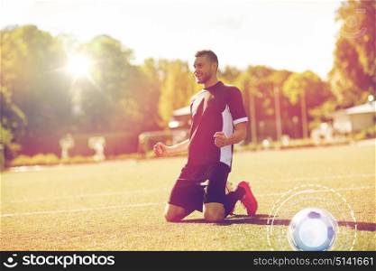 sport, success and people - happy soccer player with on football field. happy soccer player with ball on football field