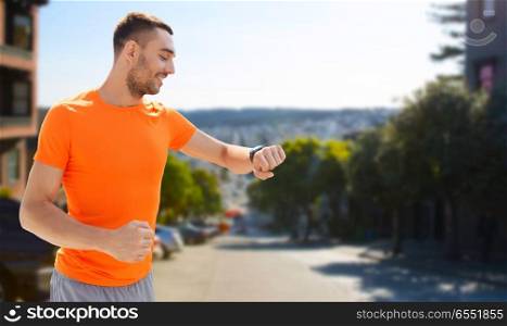 sport, technology and healthy lifestyle concept - smiling young man with smart watch or fitness tracker over san francisco city background. man with smart watch or fitness tracker. man with smart watch or fitness tracker