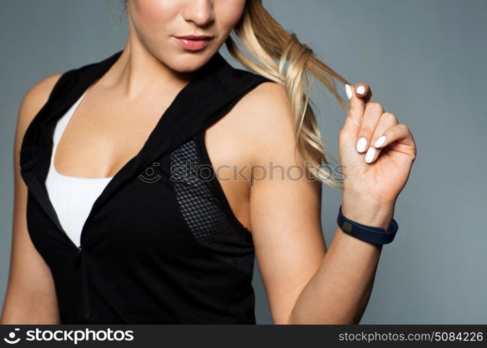sport, technology and people concept - close up of young woman in black sportswear with fitness tracker posing in gym. close up of sporty woman with fitness tracker. close up of sporty woman with fitness tracker
