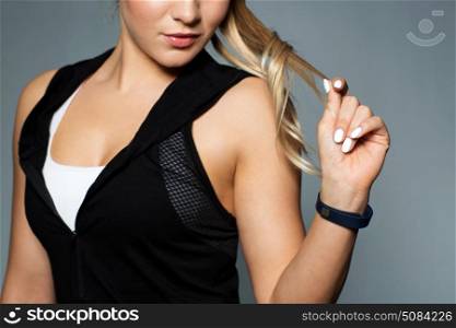 sport, technology and people concept - close up of young woman in black sportswear with fitness tracker posing in gym. close up of sporty woman with fitness tracker. close up of sporty woman with fitness tracker