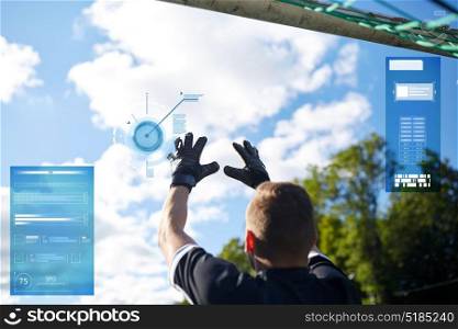 sport, technology and people concept - soccer player or goalkeeper catching ball at football goal on football field. goalkeeper with ball at football goal on field