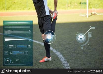 sport, technology and people concept - soccer player stretching leg on football field. soccer player stretching leg on field football