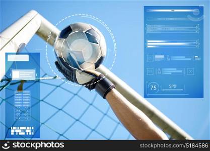 sport, technology and people - soccer player or goalkeeper hand catching ball at football goal over blue sky. goalkeeper with ball at football goal over sky