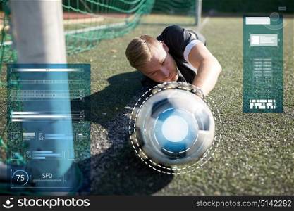 sport, technology and people - soccer player or goalkeeper lying with ball at football goal on field. goalkeeper with ball at football goal on field