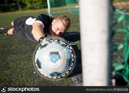 sport, technology and people - soccer player or goalkeeper lying with ball at football goal on field. goalkeeper with ball at football goal on field