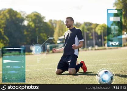 sport, technology, success and people concept - happy soccer player with on football field. happy soccer player with ball on football field