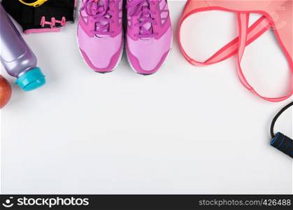 sport textile shoes and other items for fitness on a white background, top view, copy space