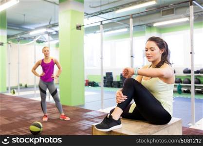 sport, training and people concept - women with fitness tracker and medicine ball in gym. women with fitness tracker and ball in gym
