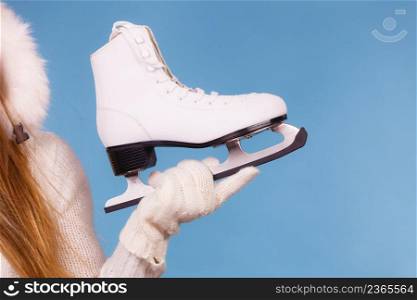 Sport, winter, people concept. Winterly equipment, white skate in female hand. Winterly equipment, white skate.