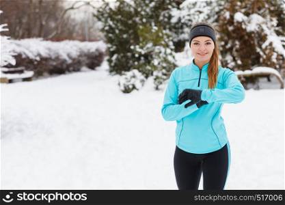 Sport winter people concept. Young lady doing workout in park. Beautiful girl jogging around outside, enjoying wintry time. Woman wearing blue top and leggins.. Young lady doing workout in park.