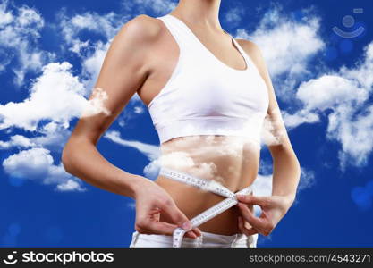 Sport woman and fitness. Woman in sport wear standing and measuring herself with a meter