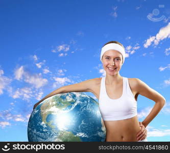 Sport woman and our planet. Young woman in sport wear with a model of our planet. Elements of this image are furnishes by NASA