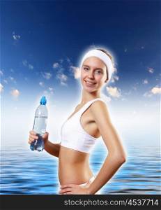 Sport woman and pure water. Young pretty woman in sport wear holding a bottle with pure water
